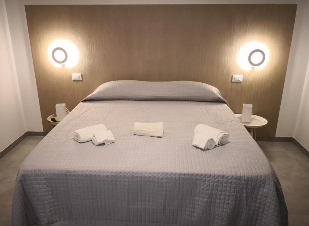 un grande letto con due asciugamani bianchi sopra di Morfino Vacanze Apartments Centro a San Vito lo Capo