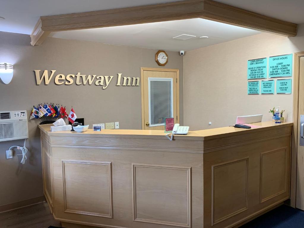 recepción de una posada en el oeste con reloj en la pared en Westway Inn Motel, en Neepawa