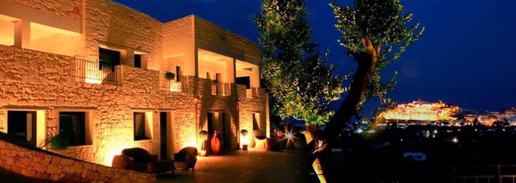 a building at night with a tree next to it at Guest House B&B Pietra Bianca in Ostuni