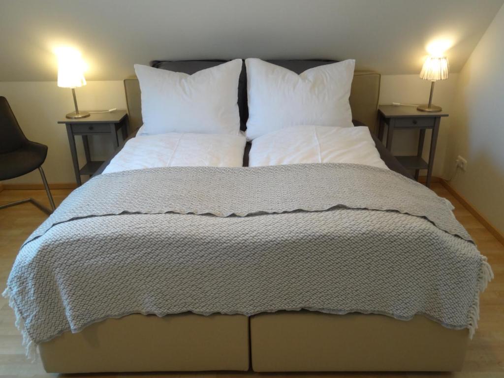 duże łóżko z białą pościelą i poduszkami w obiekcie Kleine Mathilde w mieście Fehmarn