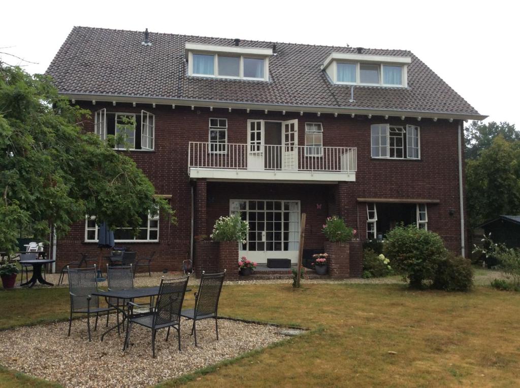 a house with a table and chairs in the yard at BergOpwaerts in Sint Odiliënberg