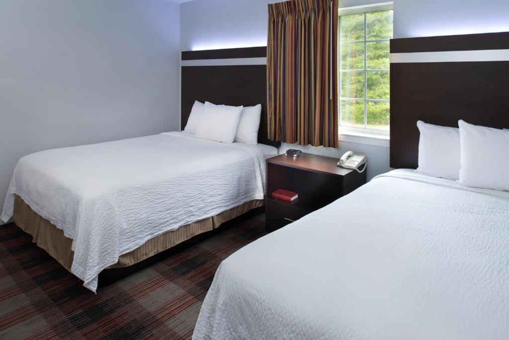 a hotel room with two beds and a window at Luxbury Inn & Suites in West Maryville