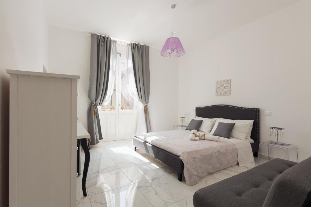 a white bedroom with a bed and a couch at Calafatari B&B in Siracusa