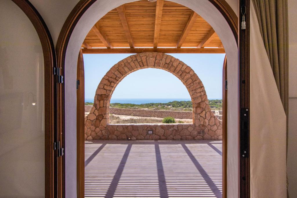 an open door to a patio with a view of the ocean at Casa Zita Lampedusa in Lampedusa