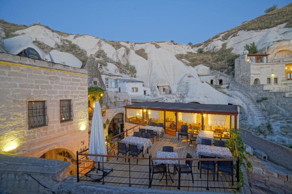 a building with a patio with tables and chairs at Melek Cave Hotel in Goreme