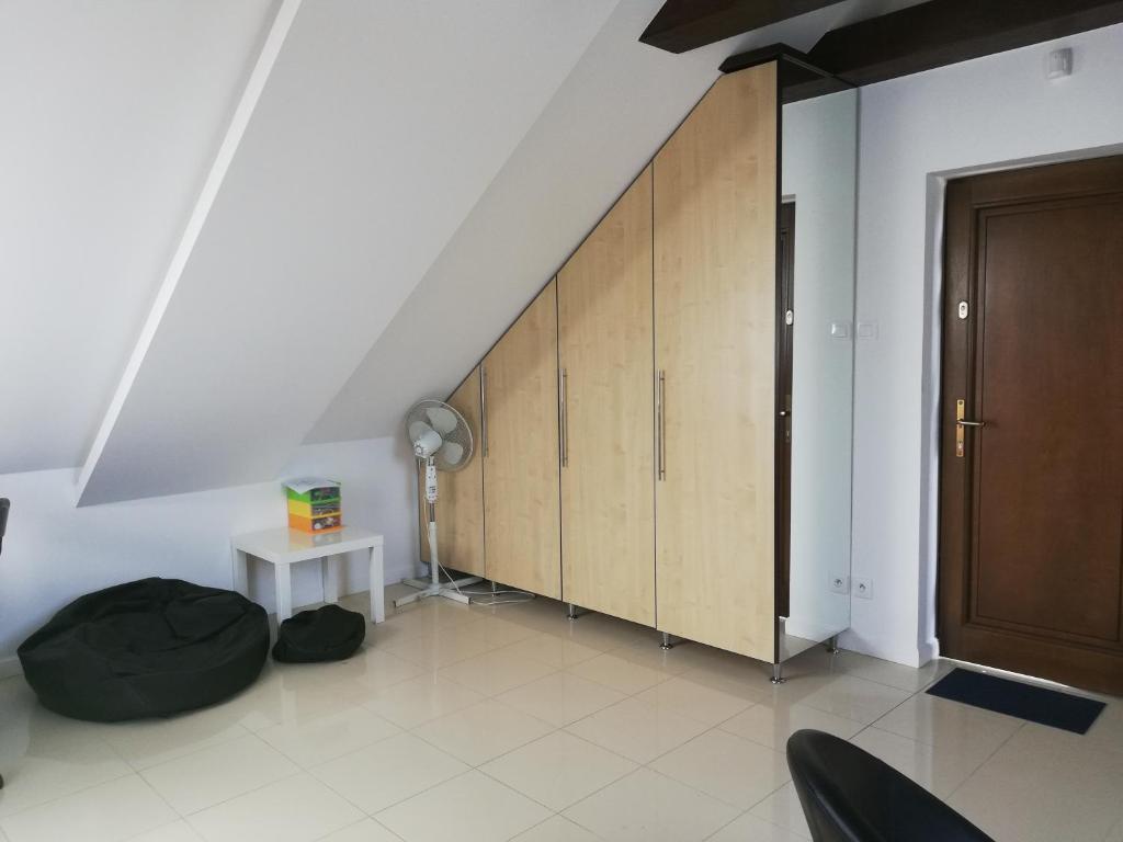 Habitación con escalera, armarios de madera y mesa. en Słoneczne Zacisze, en Wicko