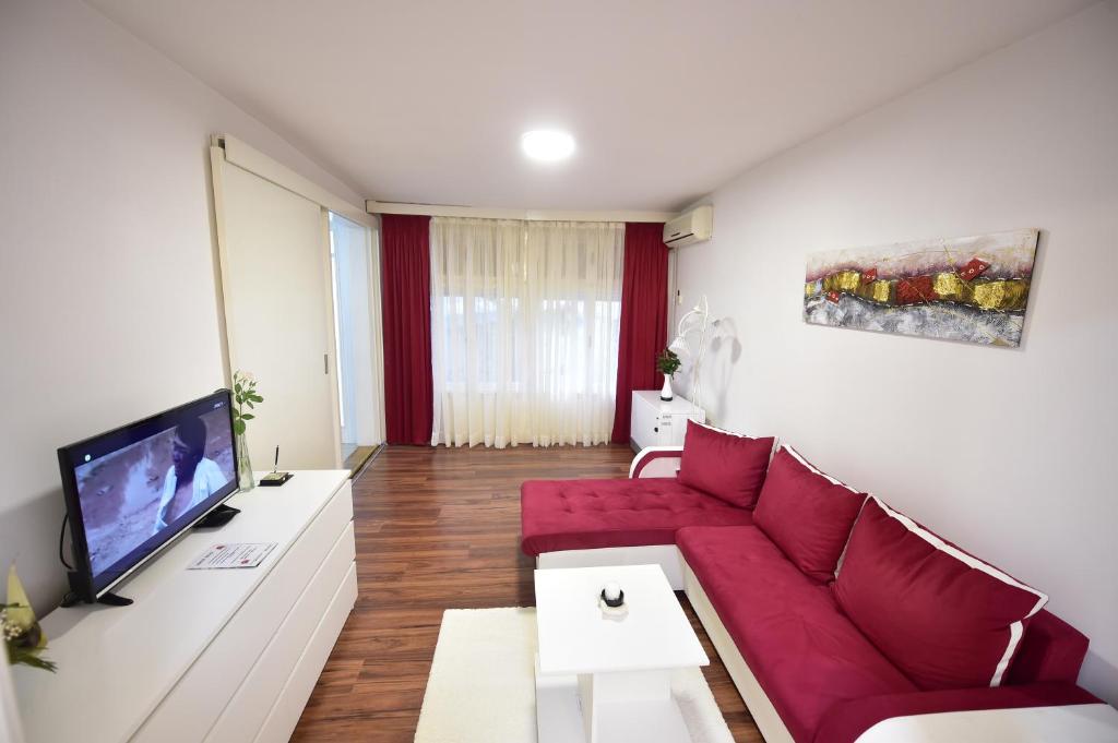 a living room with a red couch and a tv at Gardos house above Danube in Belgrade