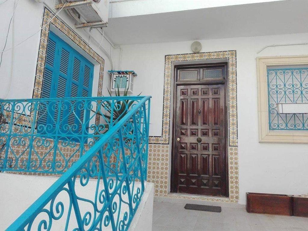 a staircase with a blue railing next to a door at Mouhib Sidi Bou Saïd House in Sidi Bou Saïd