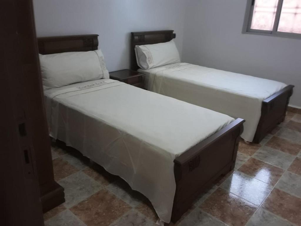 two twin beds in a room with at Coopérative Village Jbel Moussa du Tourisme in Rcham
