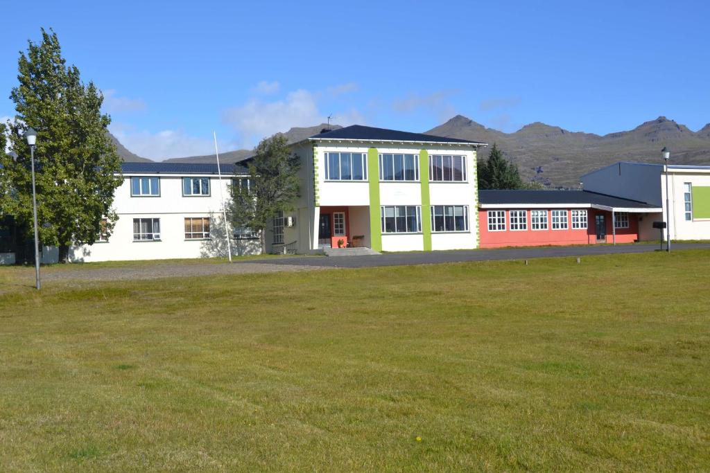 a large building with a field in front of it at Hotel Stadarborg in Breiðdalsvík