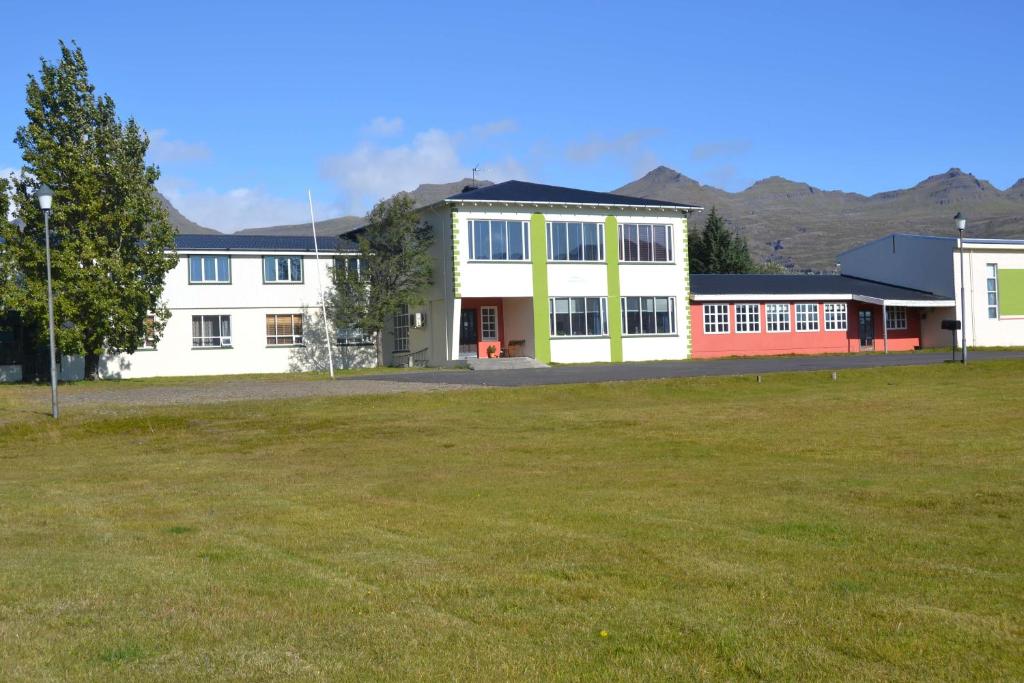 um grande edifício com um campo à sua frente em Hotel Stadarborg em Breiddalsvik