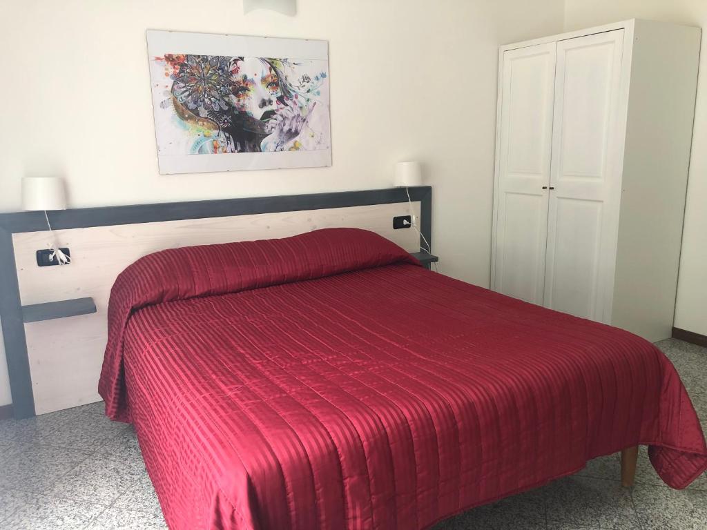 a bedroom with a red bed with a red blanket at La Casa di Anna in Delebio