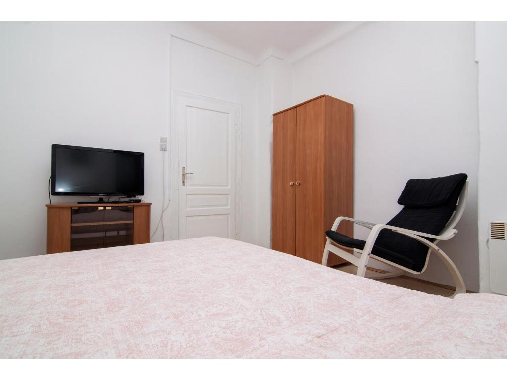 um quarto com uma cama, uma cadeira e uma televisão em Apartment in centre with huge terace em Pula