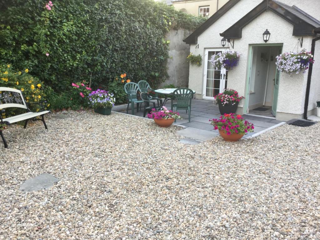 a patio with a table and chairs and flowers at Crammond House in Ramelton