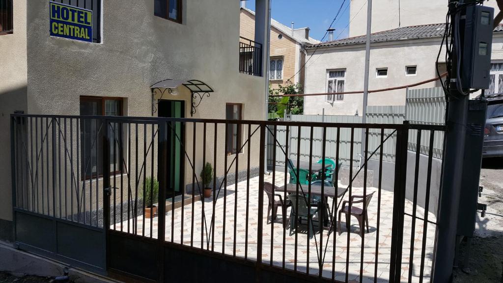 a fence with a table and a chair in front of a building at Hotel Central in Kutaisi