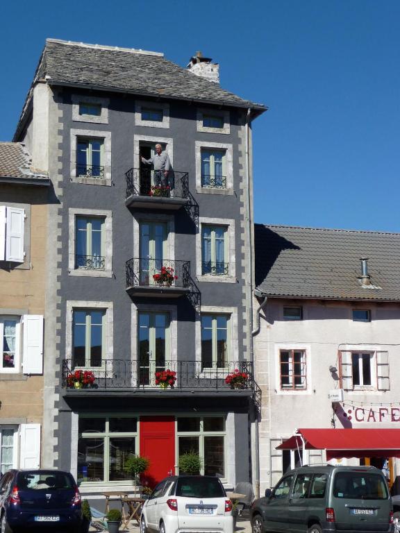 un homme debout sur un balcon d'un bâtiment dans l'établissement La Drapière, à Fay-sur-Lignon