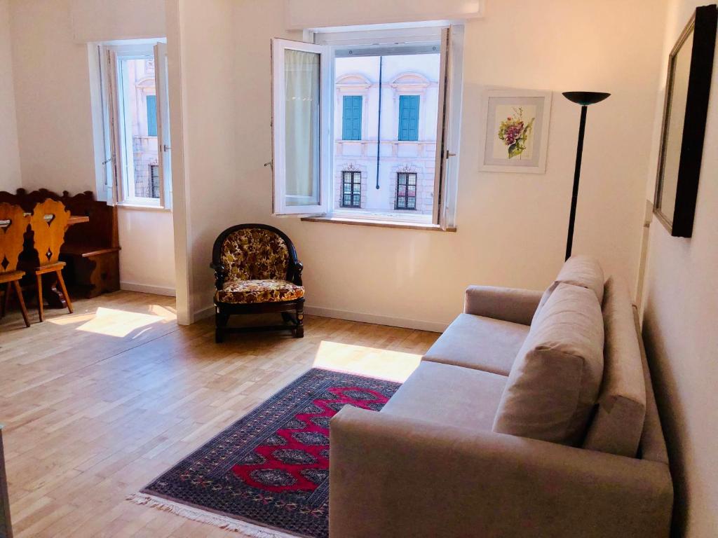 ein Wohnzimmer mit einem Sofa und 2 Fenstern in der Unterkunft Appartamento PortaPalio40 con parcheggio in Verona