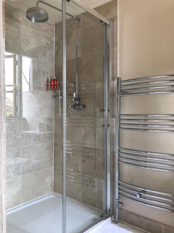 a shower with a glass door in a bathroom at The Tea House in Rye