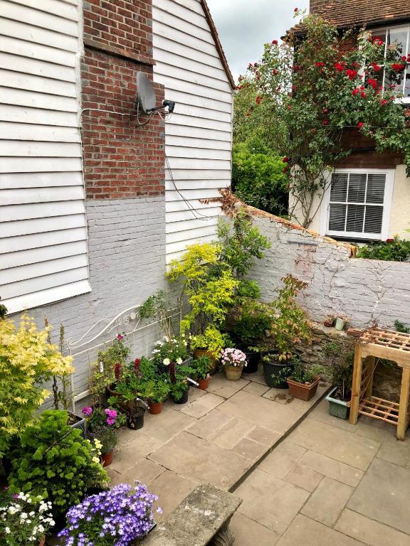 a garden with potted plants next to a house at The Tea House in Rye