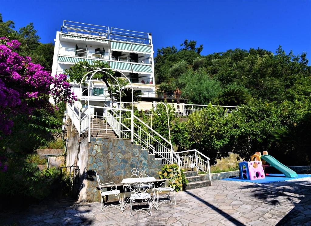 a building with a slide and a table and chairs at Villa Delle Rose in Noli