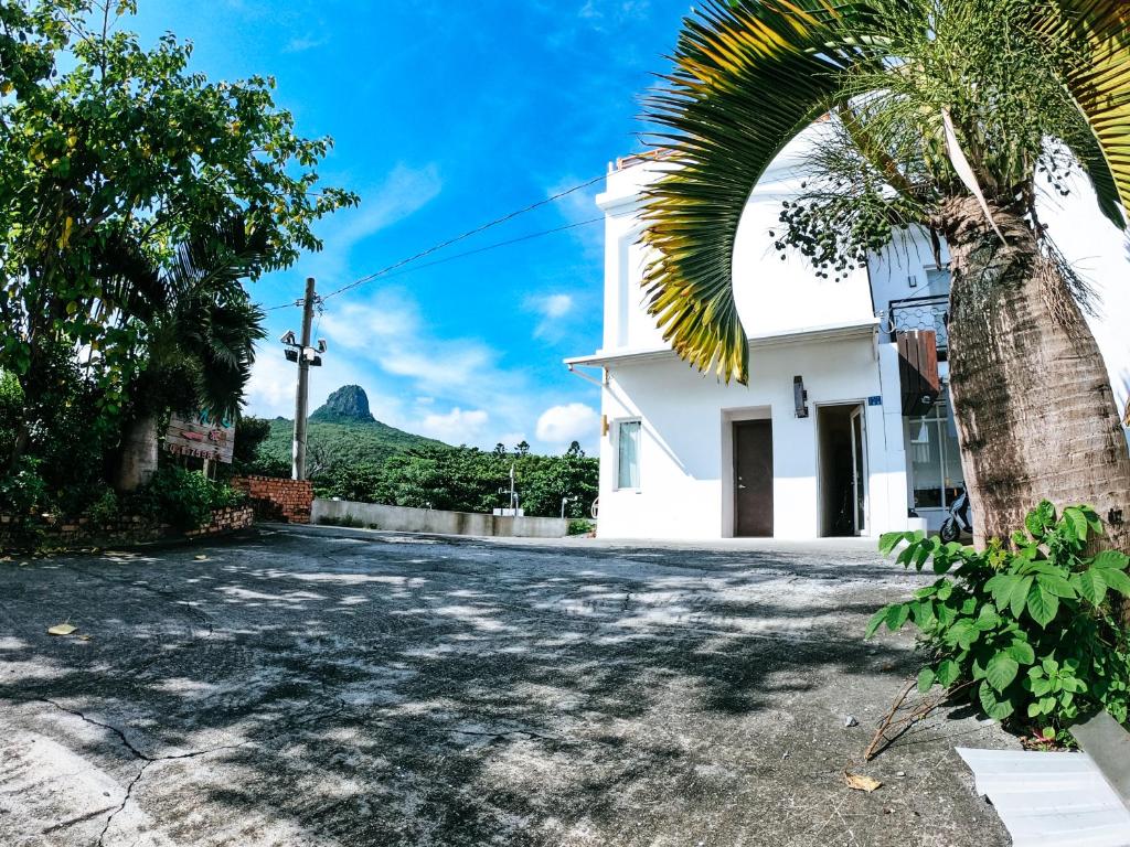 a street in front of a house with a palm tree at W24墾丁民宿墾丁大街一館bnb in Kenting