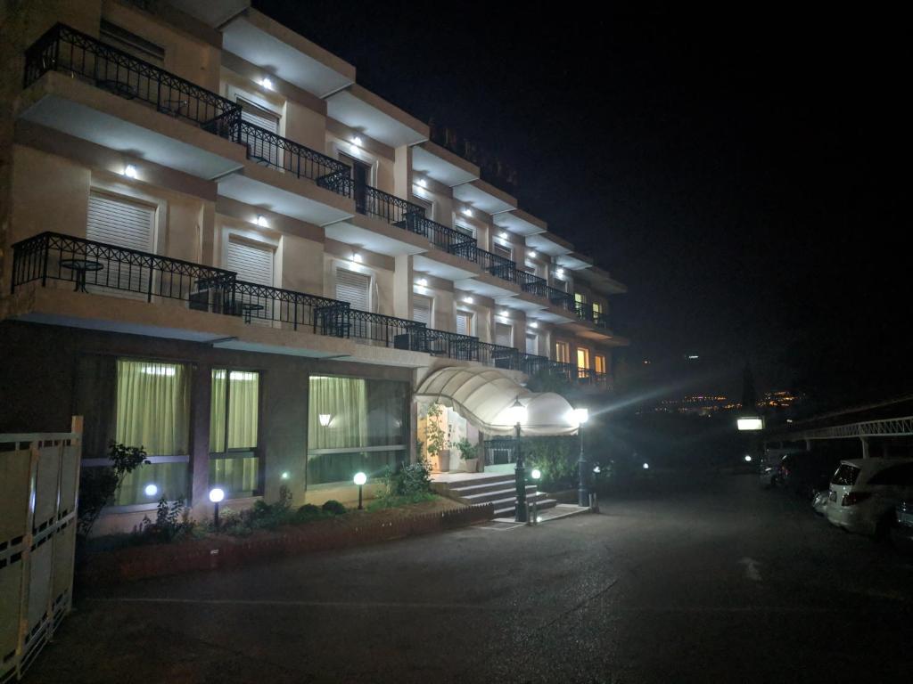 ein großes Gebäude mit seitlicher Beleuchtung in der Nacht in der Unterkunft Hotel Anesi in Athen