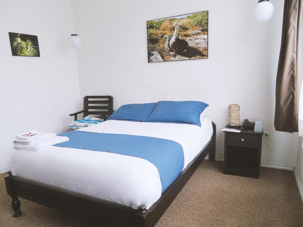 a bedroom with a bed with blue and white sheets at Bird Garden Guest House in Quito