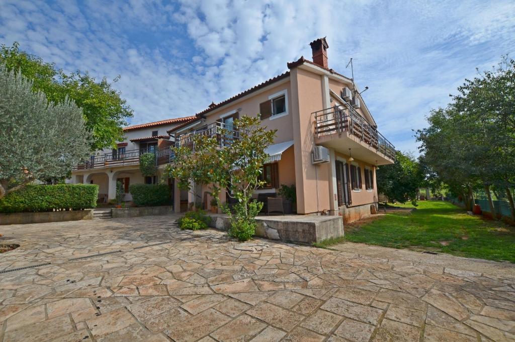 a large house with a stone driveway in front of it at Apartments Josip in Pavicini