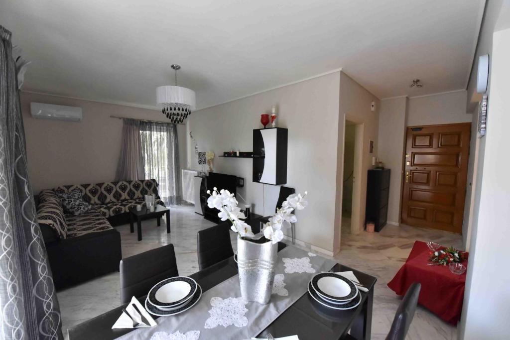 a living room with a vase of flowers on a table at Sea View Apartment in Chalkida