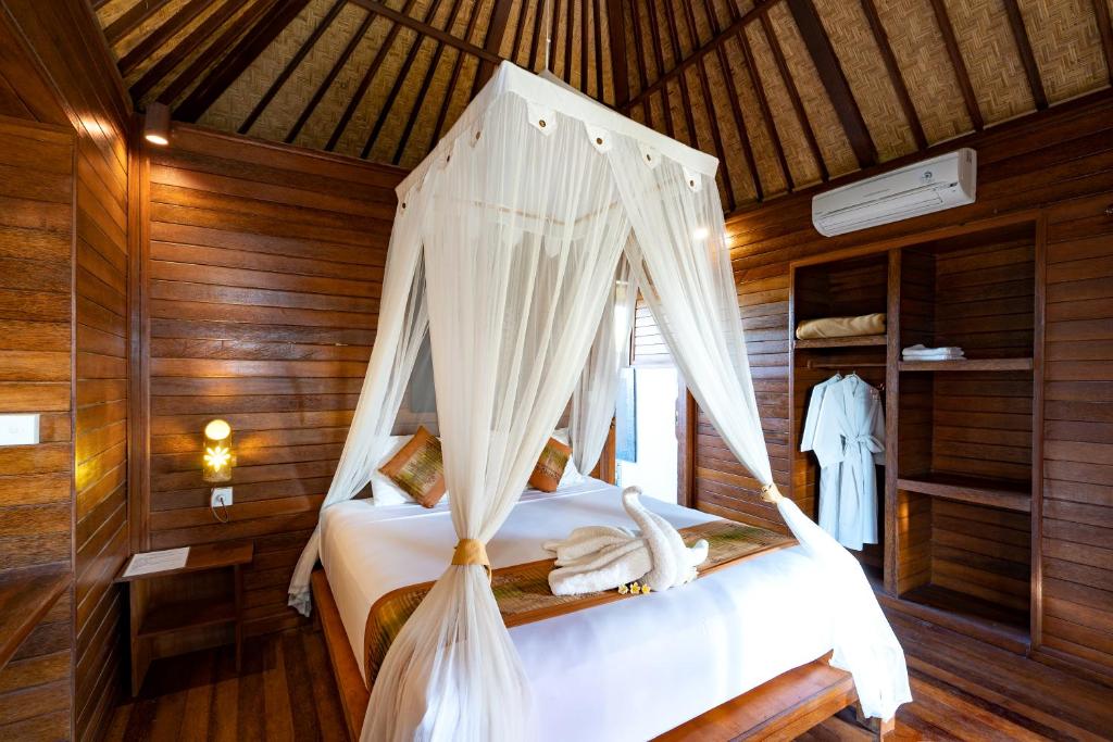 a bedroom with a bed with a canopy at Smooth Garden in Nusa Lembongan