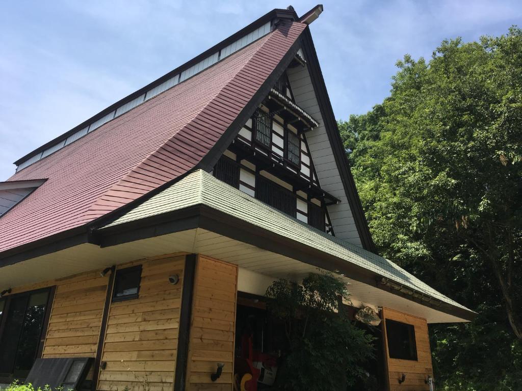a house with a gambrel roof at Guesthouse Kazura in Nanto