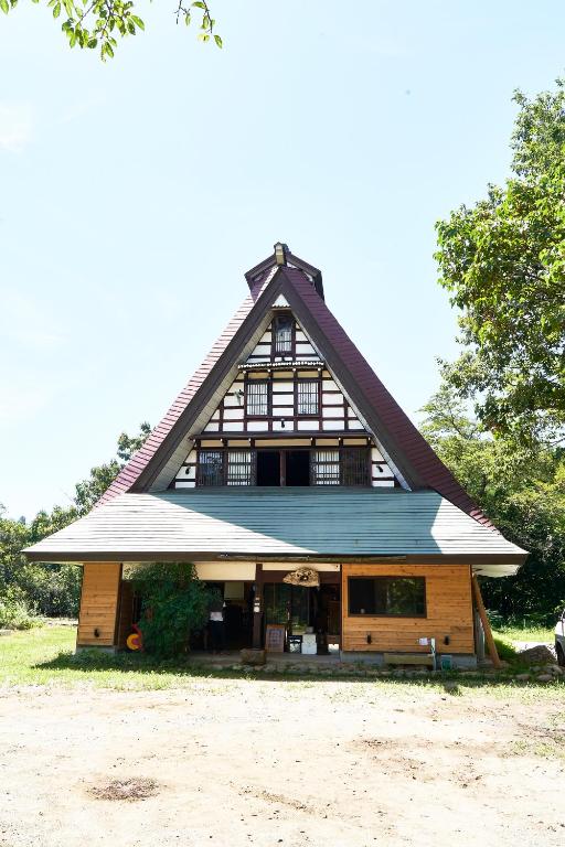 una casa grande con tejado abuhardillado en Guesthouse Kazura, en Nanto