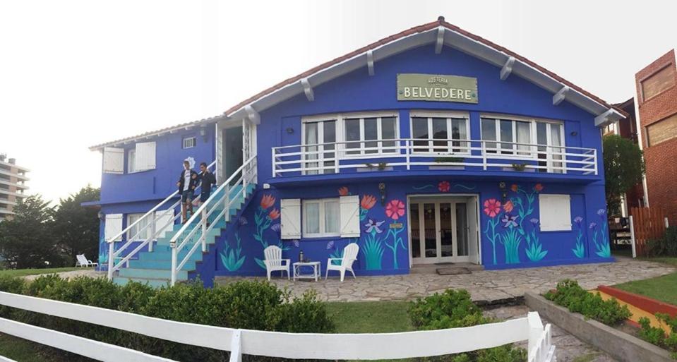 un edificio azul con flores pintadas en él en Hosteria Belvedere en Pinamar