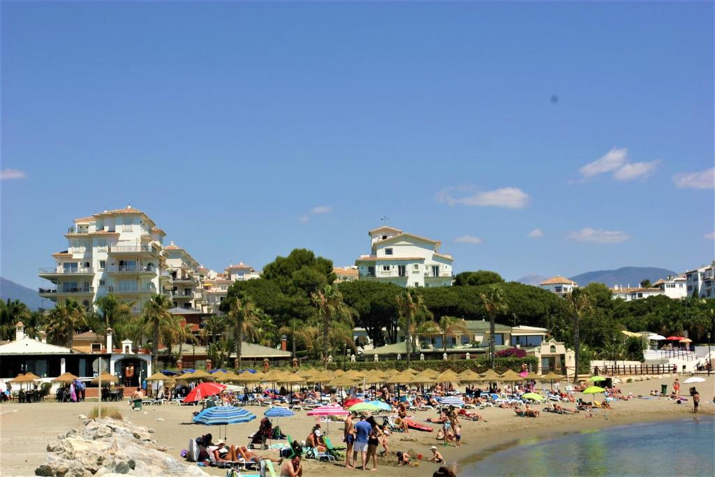 マルベーリャにあるSea view apt Puerto Banusの傘持ちの浜辺の人々