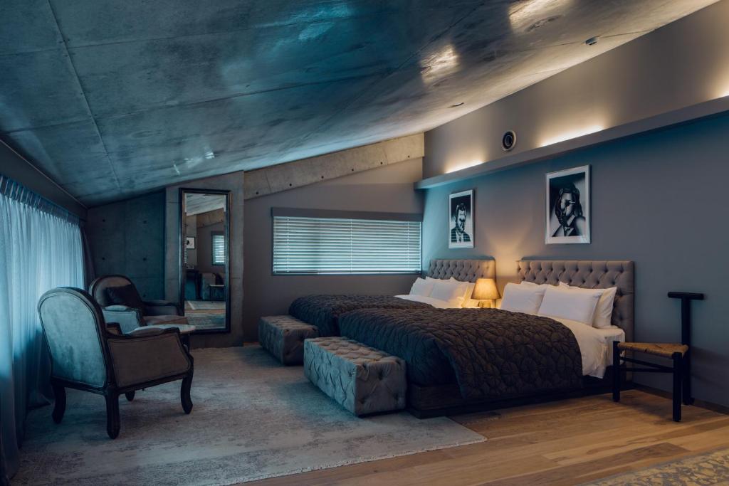 a bedroom with a large bed and a chair at node hotel a Member of Design Hotels in Kyoto