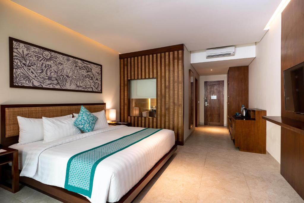 a bedroom with a large bed and a television at Anja Jimbaran in Jimbaran