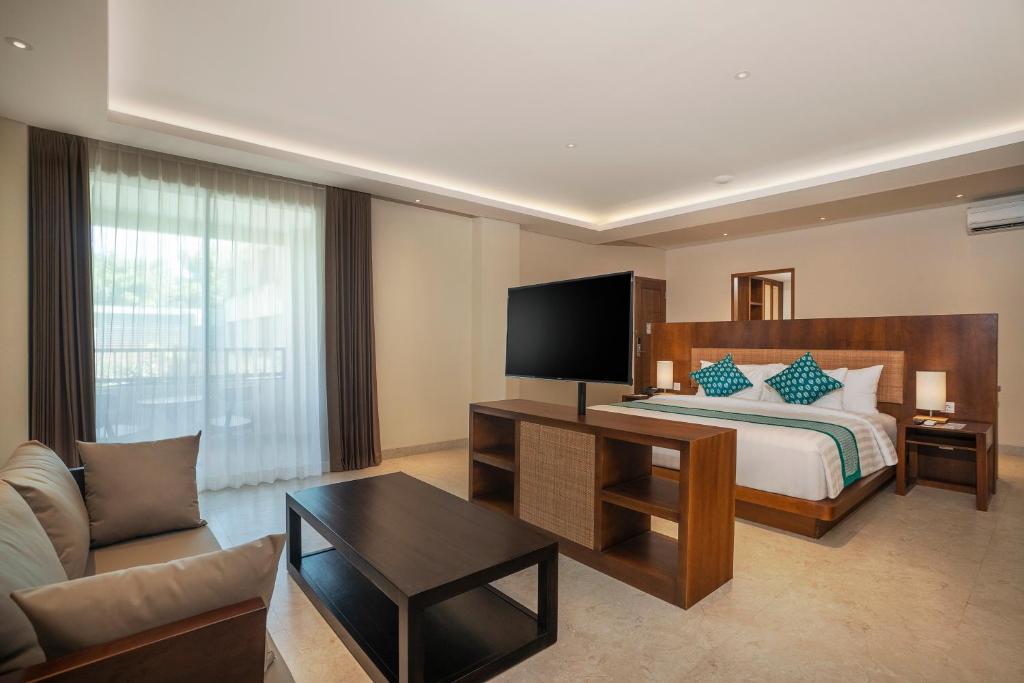 a hotel room with a bed and a couch at Anja Jimbaran in Jimbaran