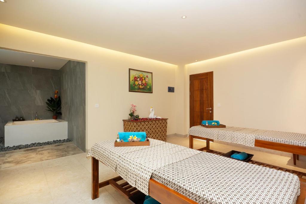 a room with two beds and a sink at Anja Jimbaran in Jimbaran