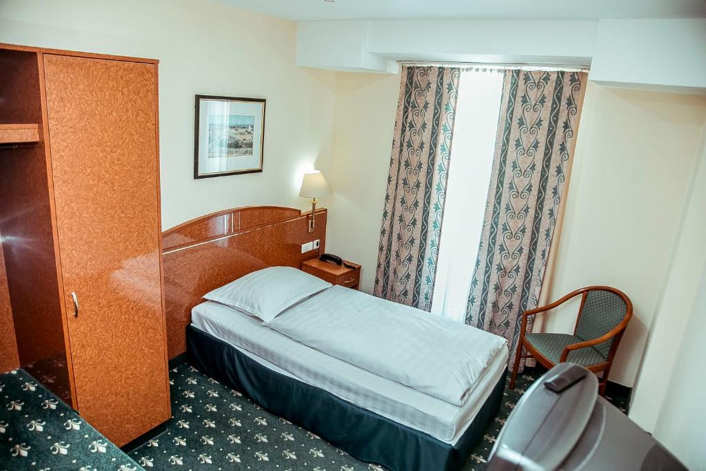a hotel room with a bed and a window at Shodlik Palace in Tashkent