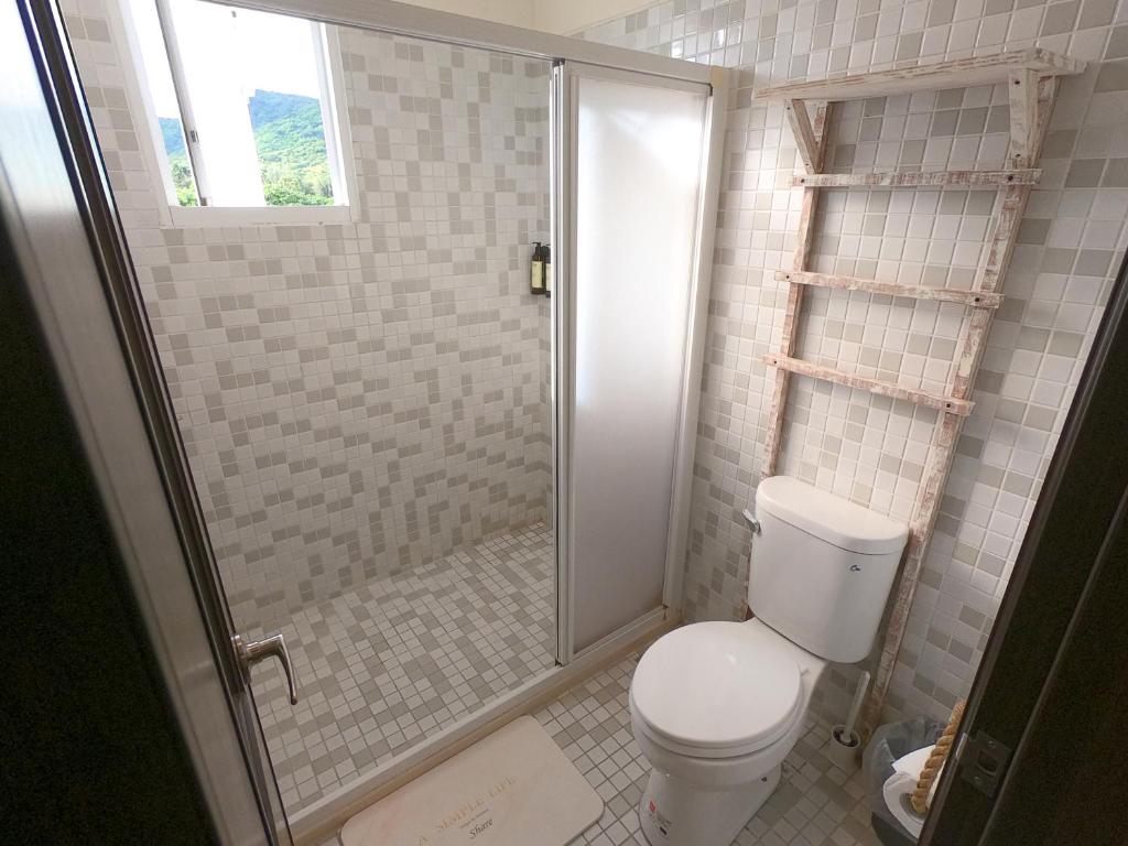a bathroom with a toilet and a glass shower at W24墾丁民宿墾丁大街一館bnb in Kenting