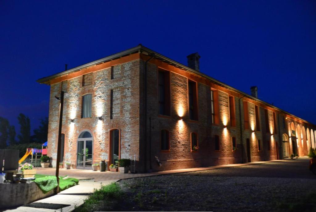 un edificio de ladrillo con luces encendidas por la noche en Agriturismo Mascudiera, en Fiorenzuola dʼArda