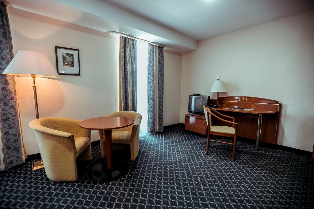 a hotel room with a desk and a table at Shodlik Palace in Tashkent