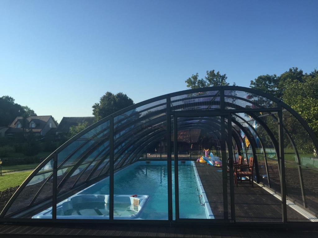 a swimming pool with a metal canopy over it at LedowoHouse in Lędowo