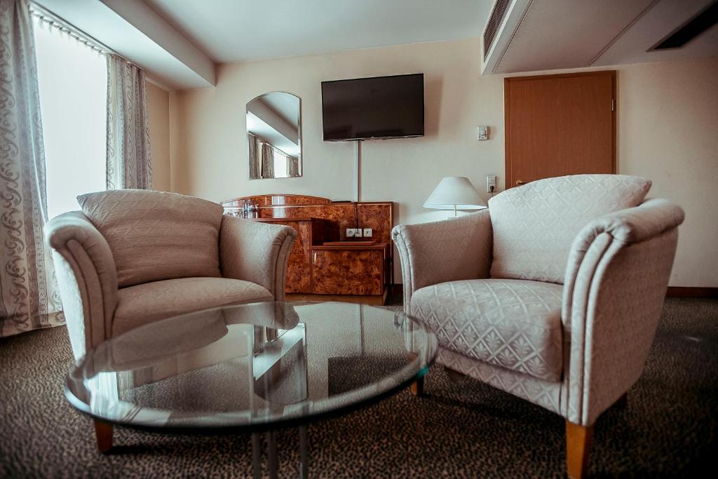 a living room with two chairs and a coffee table at Shodlik Palace in Tashkent