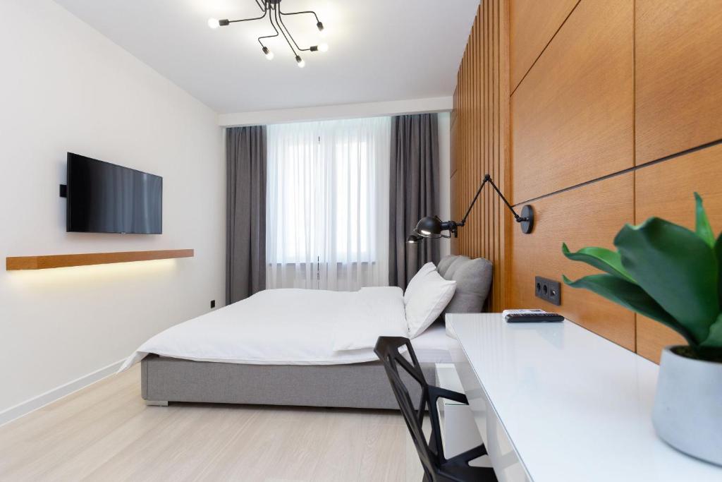 a hotel room with a bed and a table and a desk at Minsklux Apartment 2 in Minsk