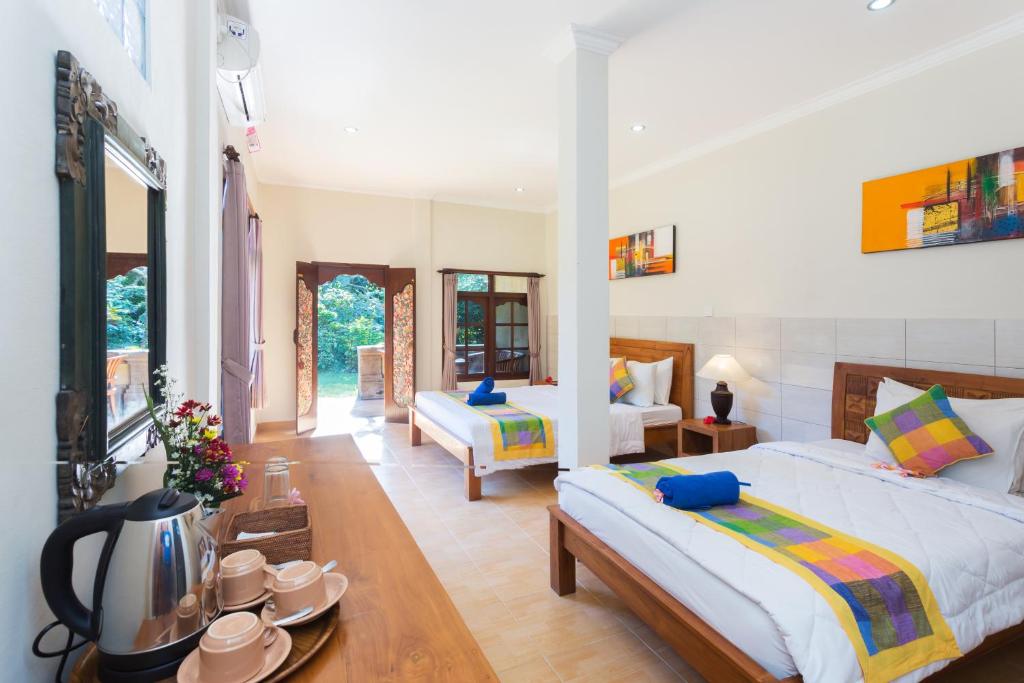 a bedroom with a bed and a living room at Wenara Bali Bungalows in Ubud