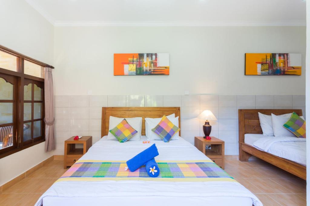 a bedroom with two beds and two tables sidx sidx sidx at Wenara Bali Bungalows in Ubud