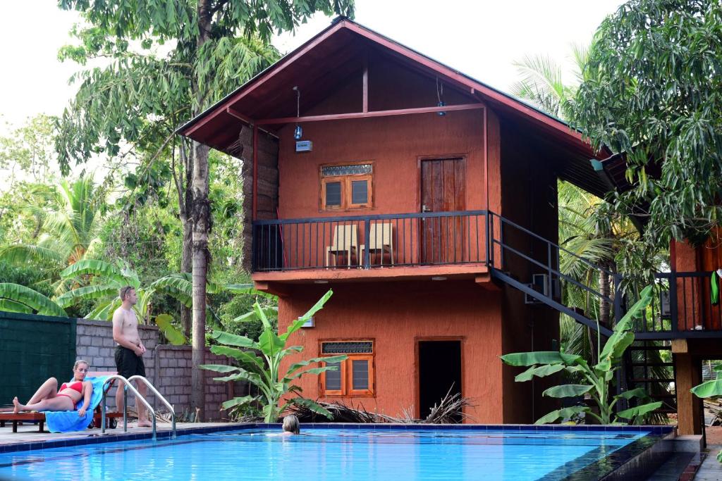 a resort with a swimming pool in front of a house at Sun and Green Eco Lodge - Dambulla in Dambulla