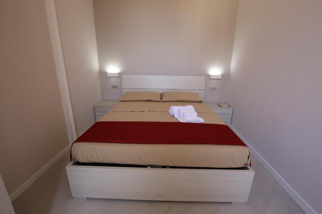 1 dormitorio pequeño con 1 cama en una habitación blanca en Casa Vacanza - Sun of Ortigia, en Siracusa