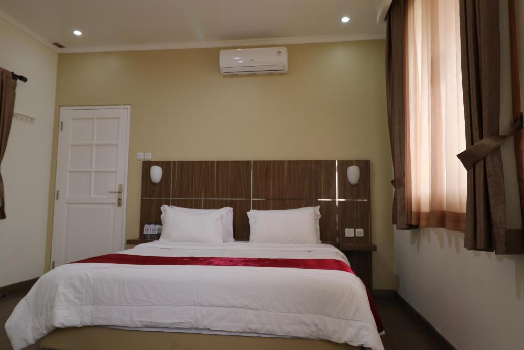 ein Schlafzimmer mit einem großen Bett mit weißer Bettwäsche in der Unterkunft Diyar Villas Puncak H8/7 in Puncak